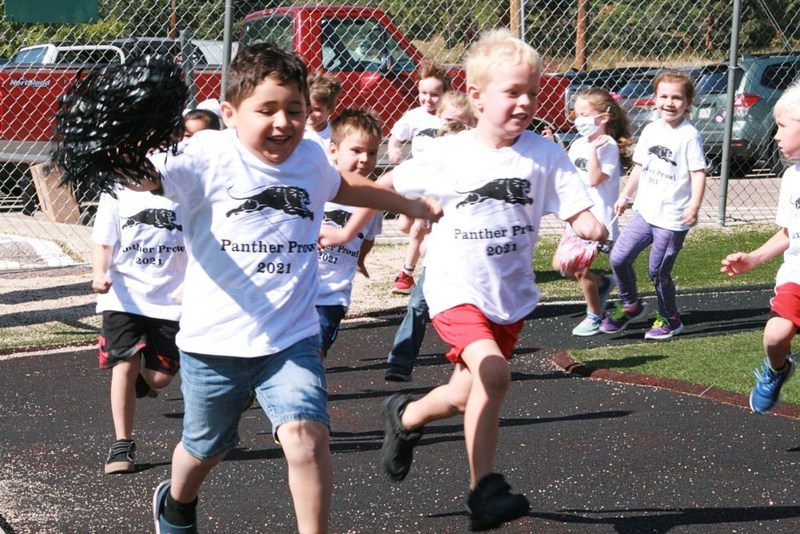 Group of children running around school track