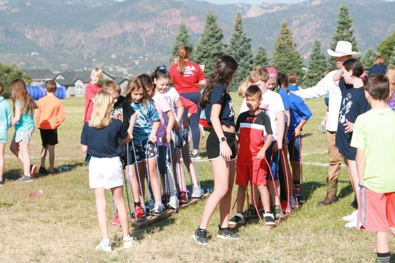 Groups of children lined up to compete in a field game on school field